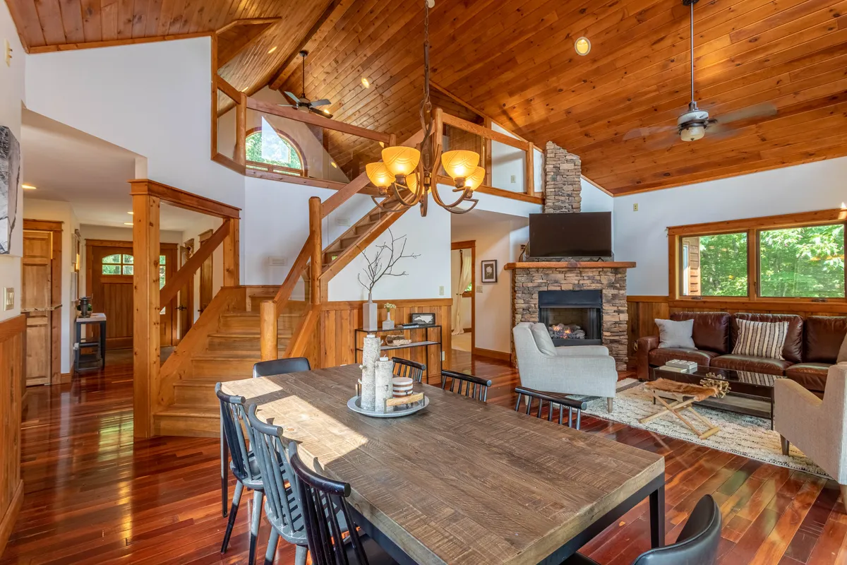 An open-plan living and dining area with a cozy fireplace, a spacious dining table perfect for board games or shared meals, and a welcoming seating arrangement that invites families to gather and connect. The ambiance is warm and inviting, ideal for both social gatherings and quiet moments together.